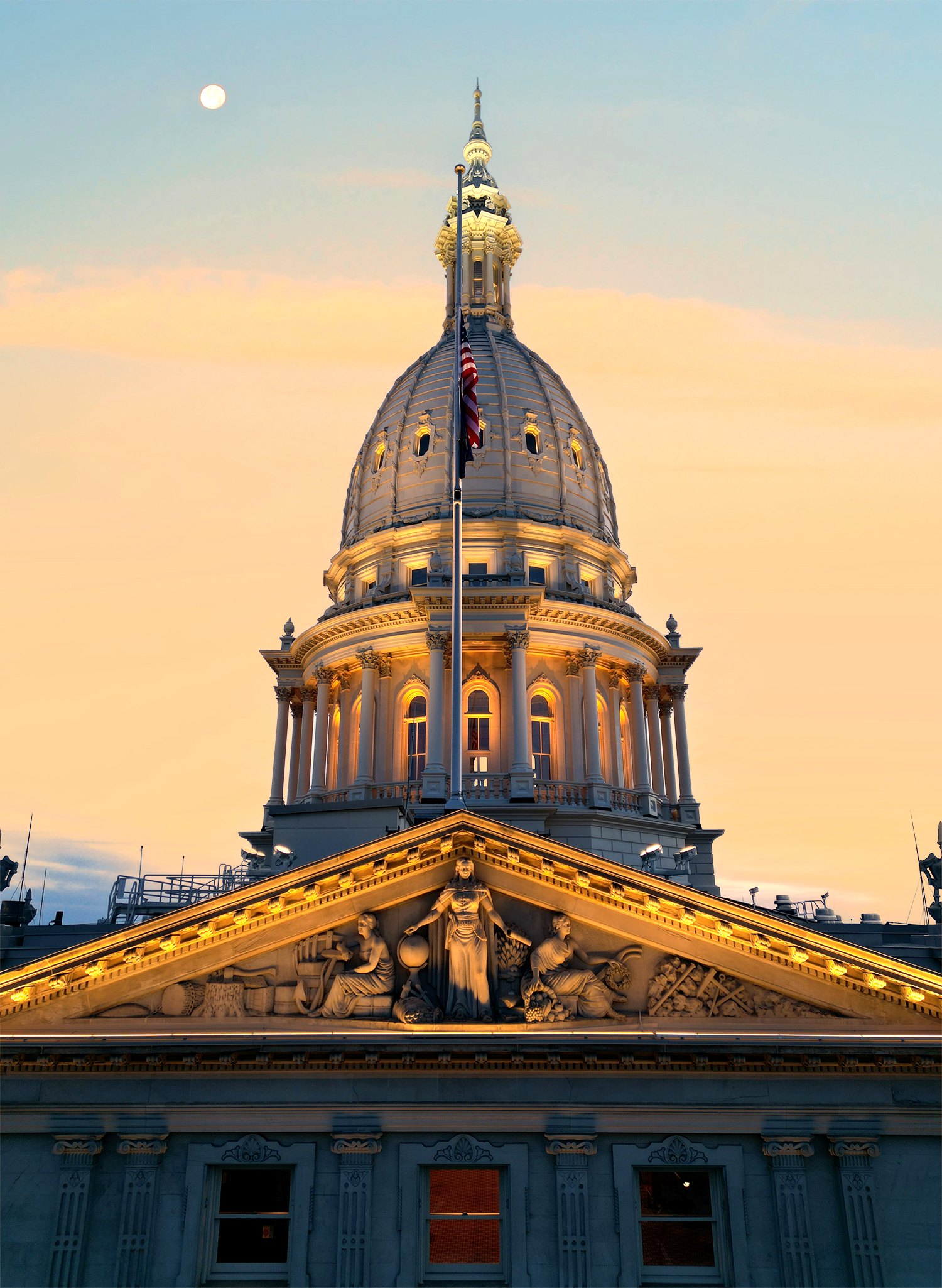 Capitol building at dusk with moon and warm architectural lighting